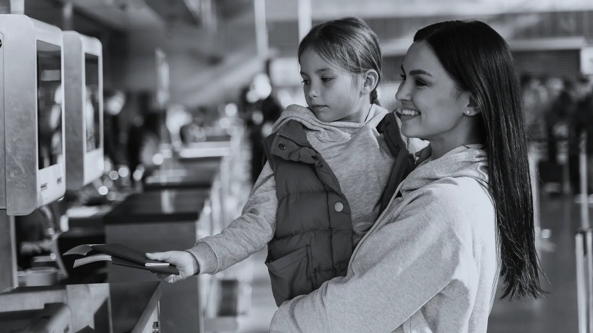 Mother and daughter handing over passports at an airport check-in counter