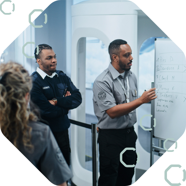 Teams of airport security and operational staff discussing in front of a whiteboard