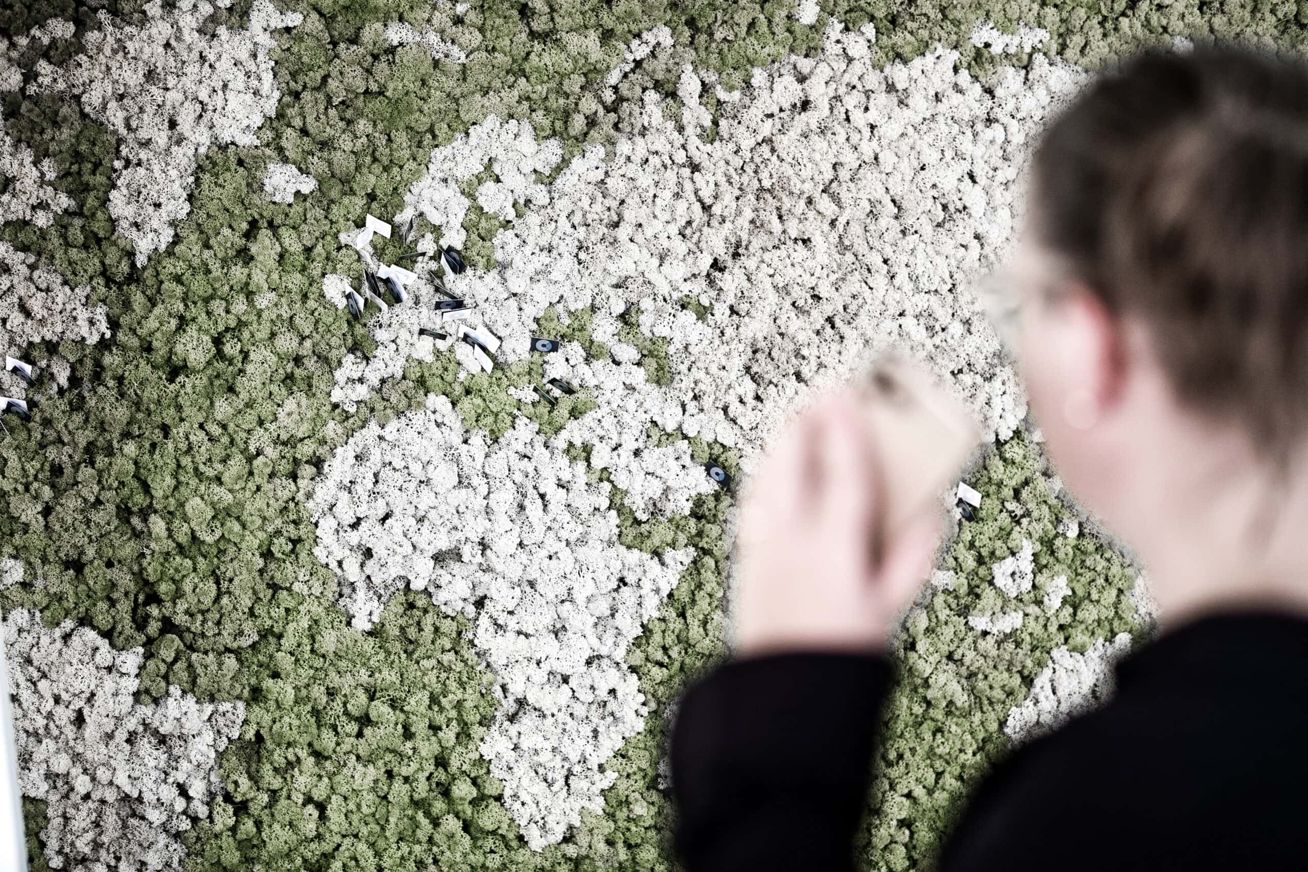 Woman with phone looking at world map